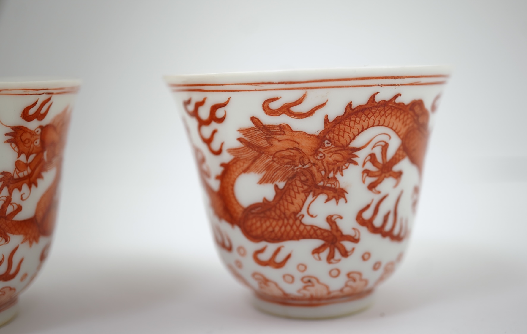 A pair of Chinese iron red ‘dragon’ cups, Guangxu six character mark and probably of the period (1875-1908)
